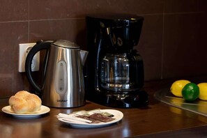 Kitchenette with dining area, stove, dishwasher, kettle, fridge freezer, toaster and cupboards.