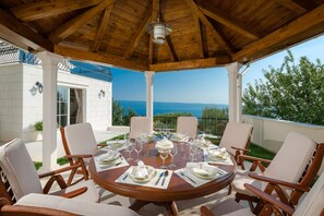 Outdoor dining area with BBQ all covered at living room and kitchen level (west)