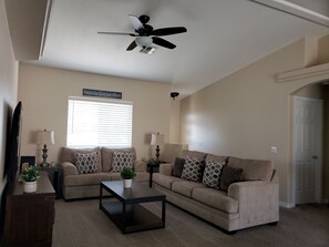 Living room with vaulted ceiling and ceiling fan 