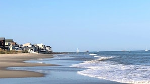 Stretch of private beach with gentle waves rolling to shore.