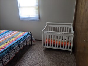 crib with mattress and bedding in master bedroom