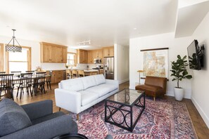 Living room with couch, coffee table, flat screen TV, and additional comfortable seating