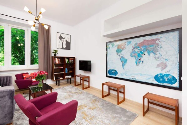 A bright living room with a vibrant purple sofa, a modern coffee table, and colorful artwork on the walls.
