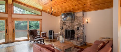 Great Room with Vaulted Ceilings, Wood Floors, Leather Sectional, and Glass Doors to Front Porch