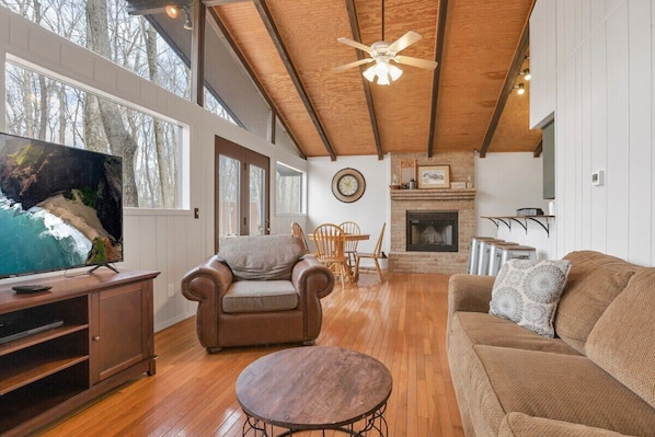 Living room with large windows and door leading to front deck.