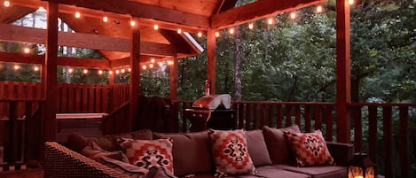 Cozy back patio with comfortable seating & flickering ambiance lights throughout