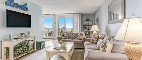 1309 Shipwatch-
Spacious Living Area with Tan Sofa and Loveseat, Flat Screen Smart TV, and Gorgeous Oceanfront Views