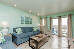 Beautiful living space with large windows and private balcony with a view of the coastal dunes and the beach