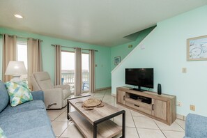 Cozy living area with flat screen TV, a great view, and stairs leading to the second floor bedrooms