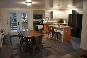 Dining room and kitchen; view out doors is of porch and woods