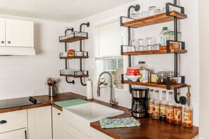 Exposed Pipe Shelving with dishes and multiple coffee syrup flavors included.
