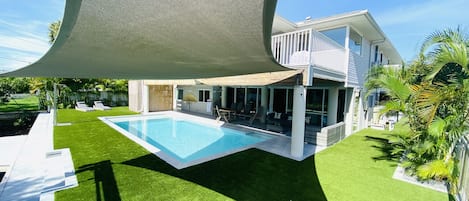 Back of house ; shade sail ; heated pool; sun loungers ; pooldeck seating for13