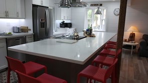 Bright kitchen with dishwasher, range, fridge, microwave and wine fridge.