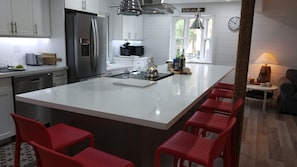 Bright kitchen with dishwasher, range, fridge, microwave and wine fridge. 