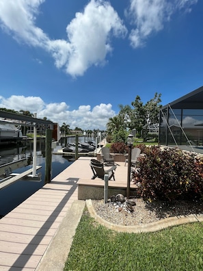 Boat lift and Adirondack seating area directly on the canal