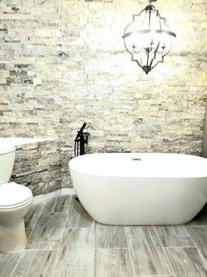 Freestanding bathroom, with beautiful real rock accent wall, custom double vanity