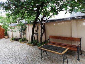 A bench with a table inside the yard at the guesthouse! 