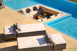 Patio with infinity pool and built-in seating area