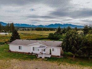 Drone shot of the home with mountain ranges in the backdrop. 