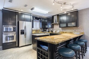 Modern kitchen with stainless steel appliances. Fully stocked with pots, pans and cooking utensils.