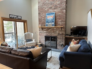 View of living room and fireplace from kitchen