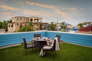Rooftop patio deck with a sunset view and peak of the ocean