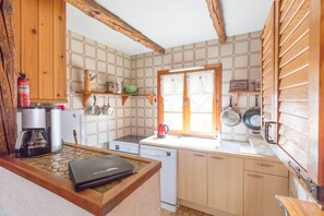 Small kitchen including large fridge, oven with 4 ring hob and dishwasher