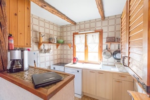 Small kitchen including large fridge, oven with 4 ring hob and dishwasher
