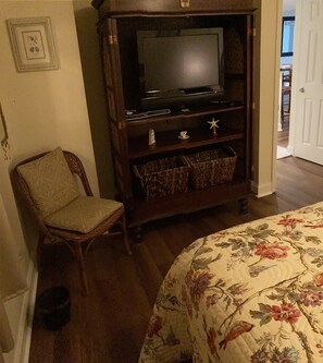 BR 1 - sitting area, wall mirror, TV in rattan hutch