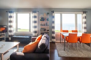 Double picture windows facing the ocean from the living/kitchen/dining area