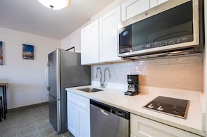 Brand new modern kitchen with stainless steel appliances, GE Profile microwave and oven in one, regular and Keurig coffee maker and quartz countertops w designer backsplash. Everything brand new.