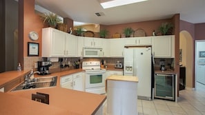 Fully equipped kitchen with modern appliances and ample space for cooking and dining.