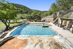 Relax poolside with panoramic hill views, a bubbling spa, and shaded seating for the perfect Texas retreat.