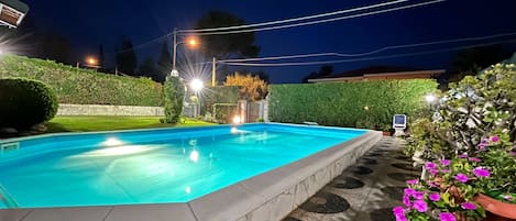 Zona piscina e giardino di notte