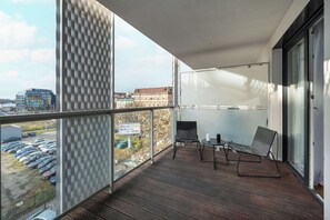 A dining setup with a table and chairs positioned near large glass doors that open to a balcony or patio area.