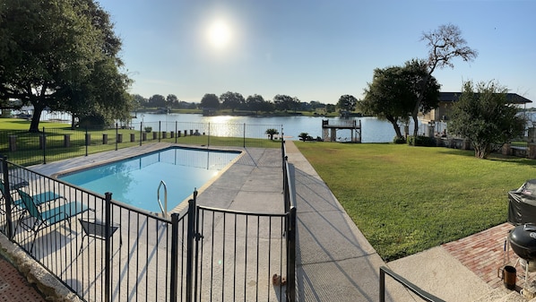 Lake frontage with yard, pool and dock