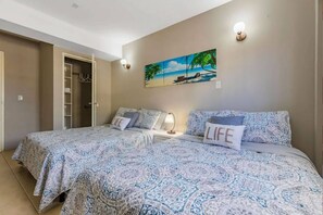 Bedroom with two double beds and closet.