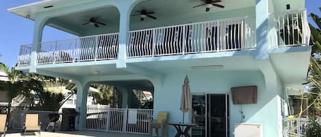 Covered balcony with see through shades and ceiling fans and dinette set 
