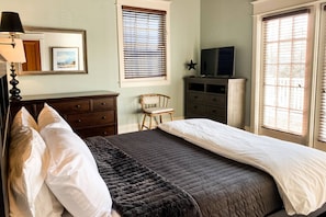 The bright Master Bedroom suite with the Queen Bed, en-suite full bath, TV and attached balcony.