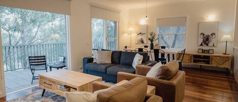 Living/dining area with fold out sofa and floor to ceiling windows 