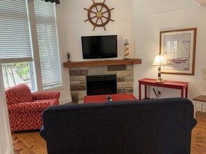 Spacious living room with cozy couches and a lovely fireplace. 