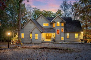 Front of the house with large circular driveway and parking.