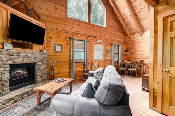 Living room with flat screen TV, electric fireplace, and queen sleeper sofa