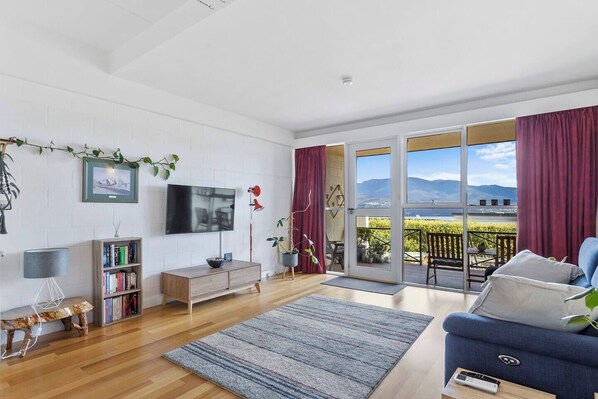 Upon entry, the home leads to a spacious living area that opens towards the deck. Relax in air-conditioned comfort as you enjoy a spot of TV.