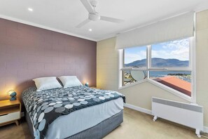 The first bedroom overlooks mountain and water views from the premium queen bed. 
