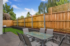 Unwind on the private patio, equipped with comfortable seating and a BBQ, perfect for alfresco dining and enjoying tranquil moments outdoors.