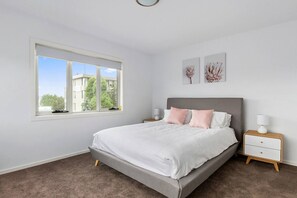 Retreat to the primary bedroom, furnished with a plush queen bed and features an ensuite bathroom for added privacy and comfort.

