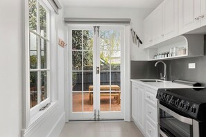 The well-equipped kitchenette is perfect for preparing a quick meal. Access the sunny courtyard through French doors and enjoy alfresco dining in a private, serene setting.