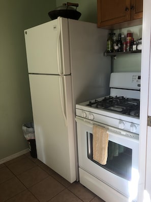 full sized refrigerator and oven in kitchen