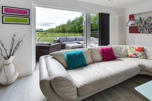 large lounge area opening out to large decked terrace and unobstructed views